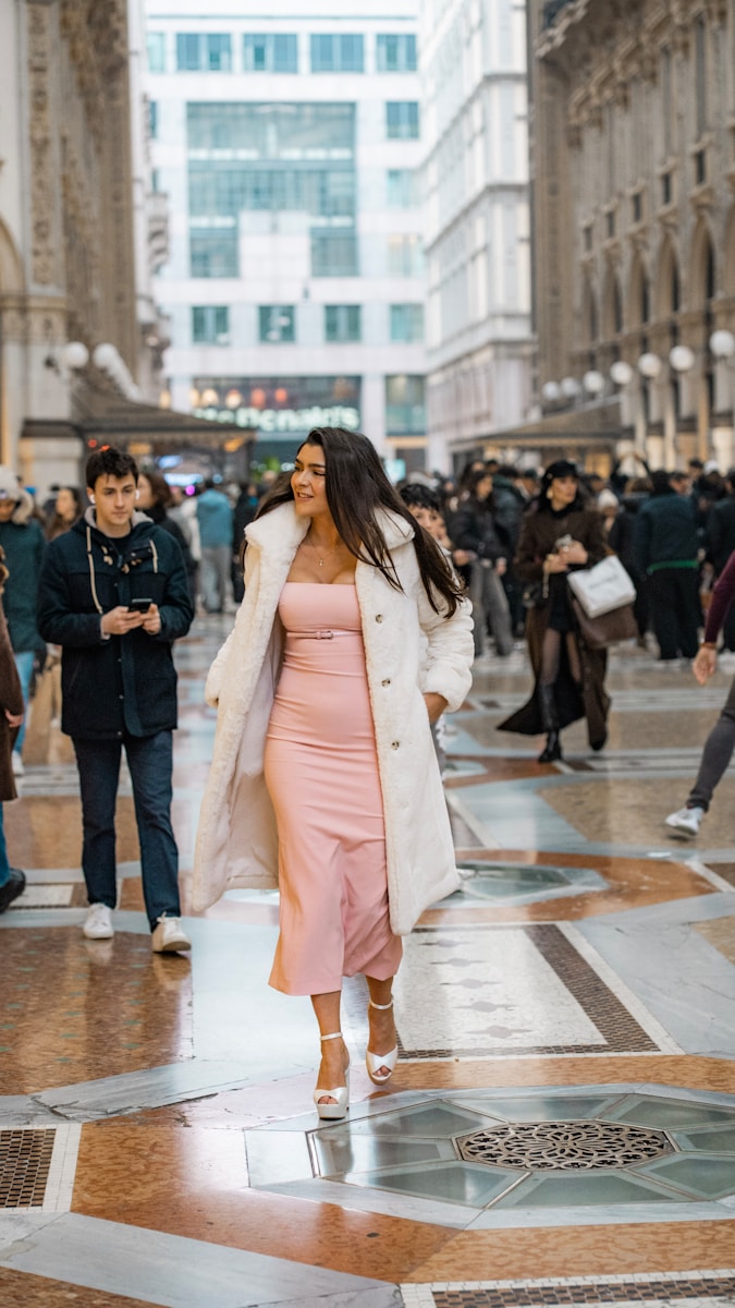 Woman walks down an ornate street.